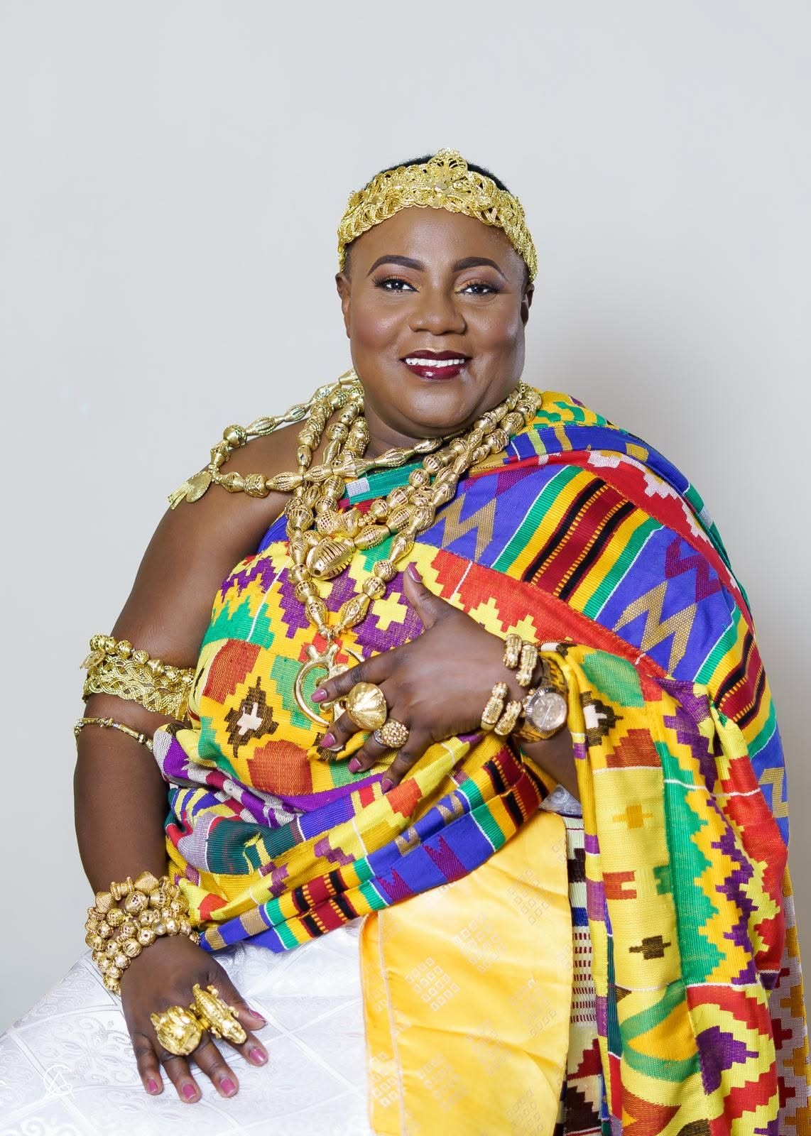 Nana Ekua Abookye VI seated in colourful ceremonial cloth and gold regalia